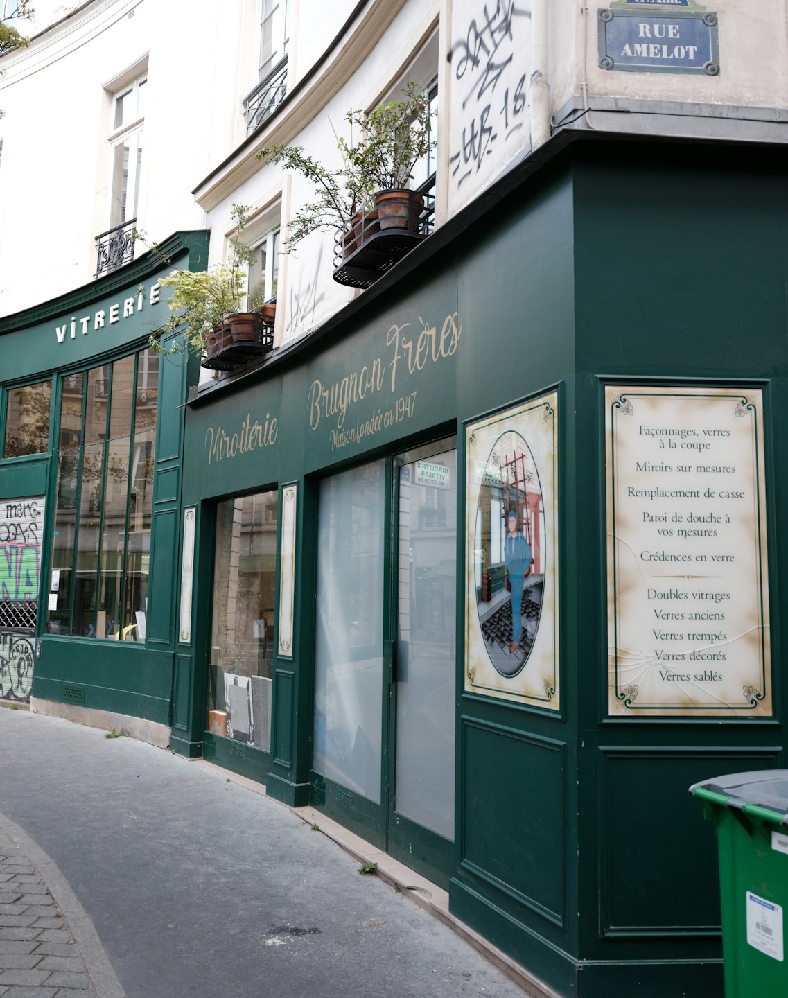Façade verte de Miroiterie Brugnon Frères dans une rue étroite.